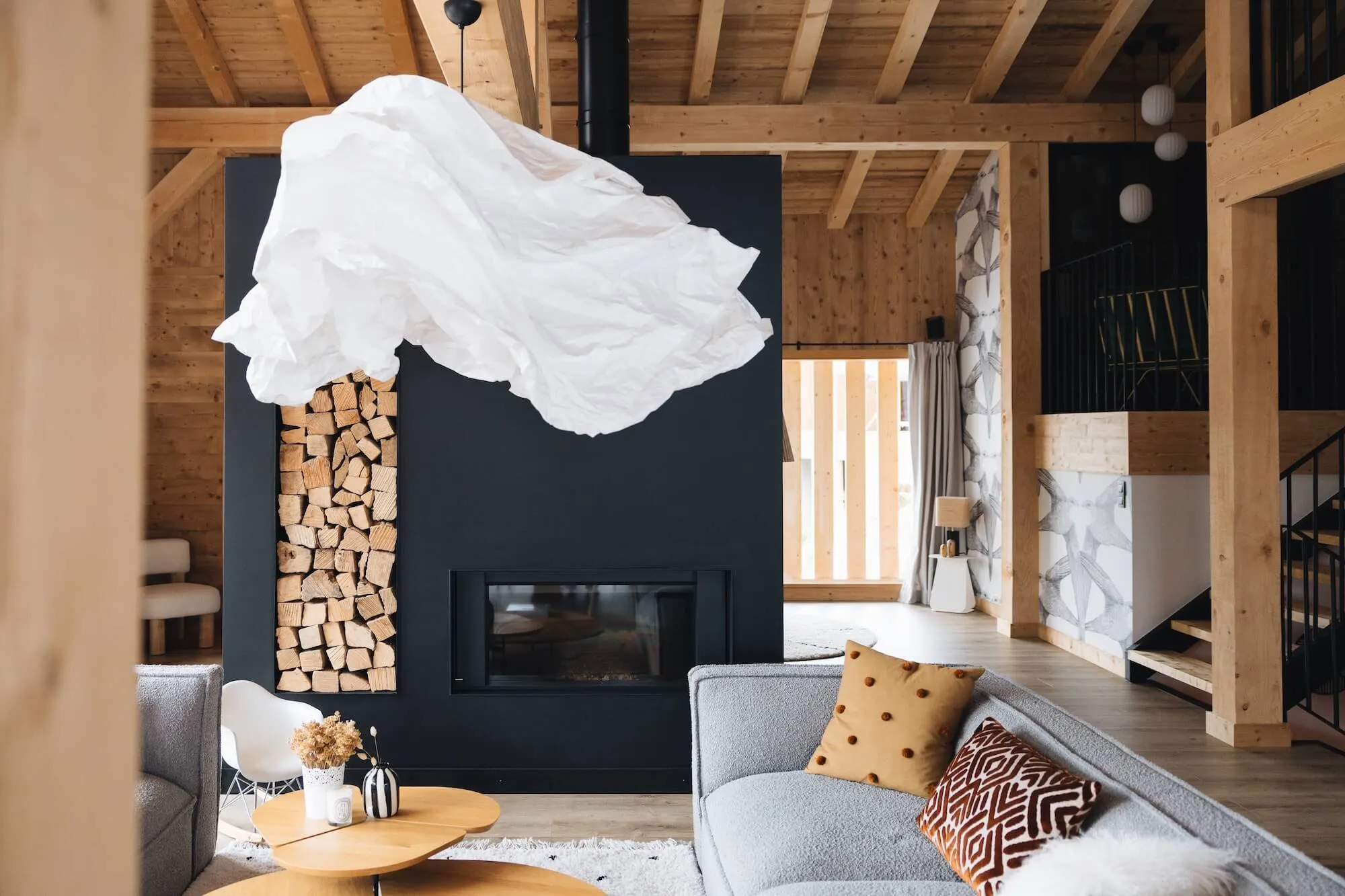 Photo d’un salon avec mise en valeur de la grande suspension en papier qui fait penser à un nuage, pensé par InSide Interior Design basé en Haute-Savoie.