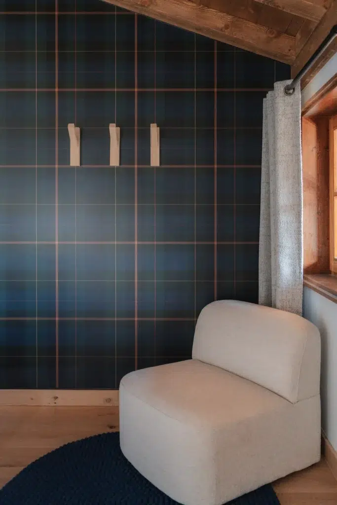 Papier peint graphique à carreaux avec un fauteuil en lin clair juste devant.