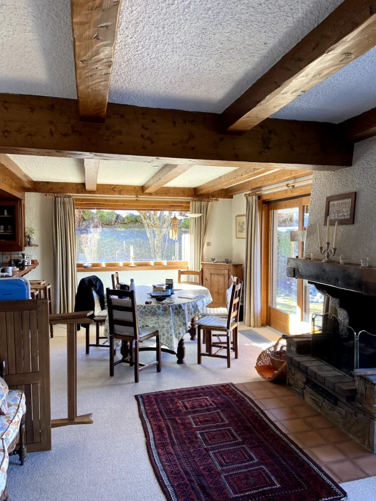 Ancien salon avant rénovation totale de ce chalet de ski à Megève, on voit les anciennes poutres, l’ancienne disposition et les espaces très lumineux.