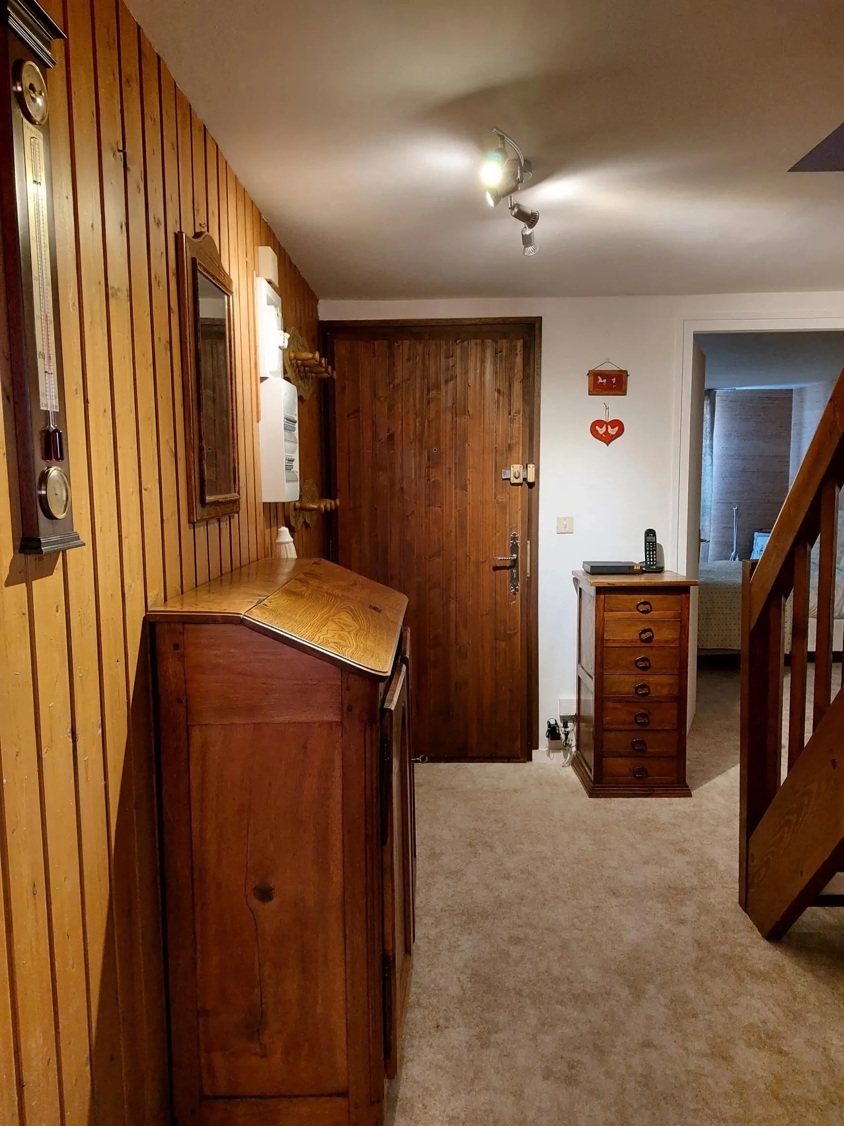 Couloir avec escalier en bois massif et lambris avant rénovation, chalet à Megève