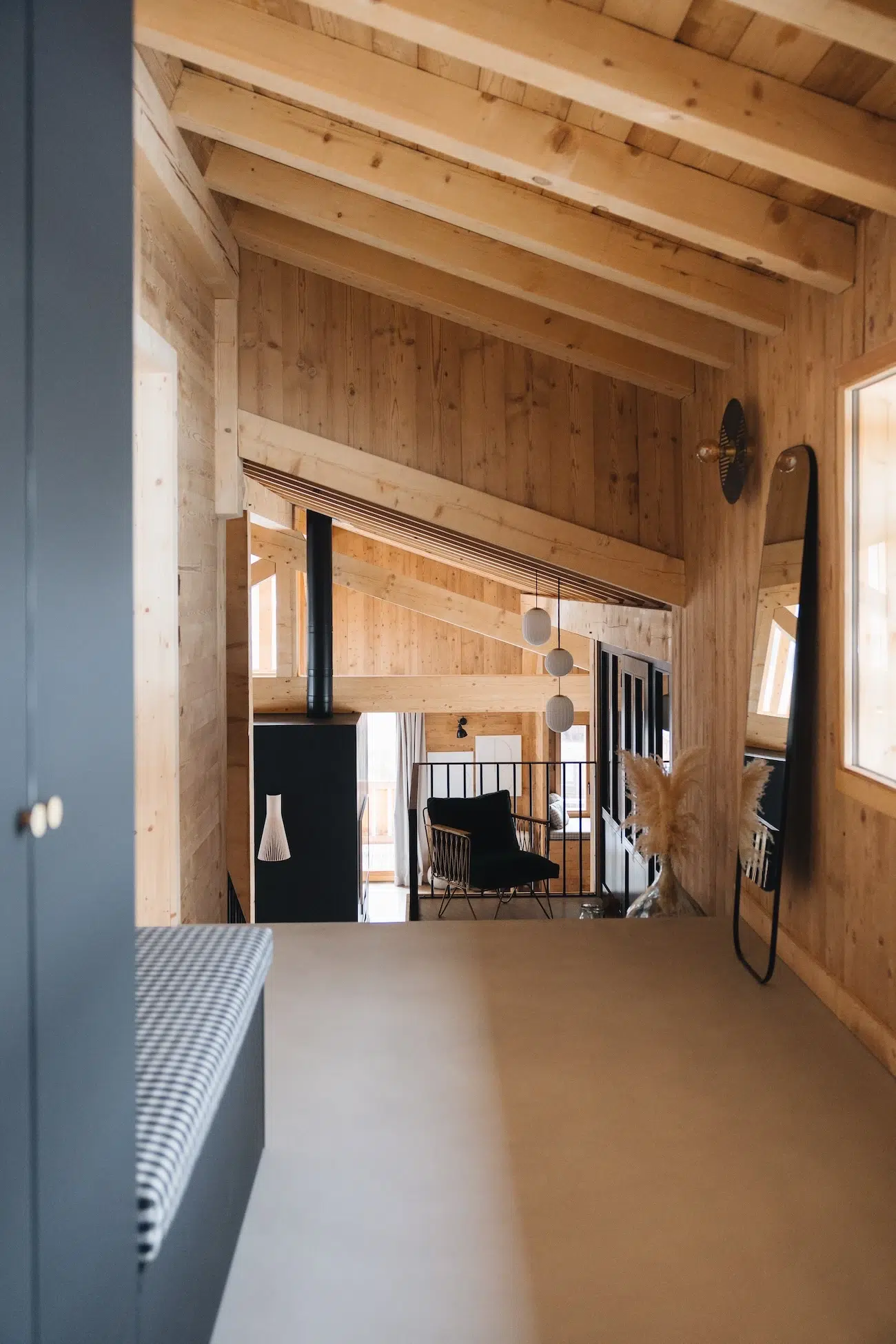 Photo d’un couloir au style montage chic tout en bois clair, l’éclairage est une applique murale bien placée à droite et non un spot au plafond. Architecte d’intérieur basée en Haute-Savoie.